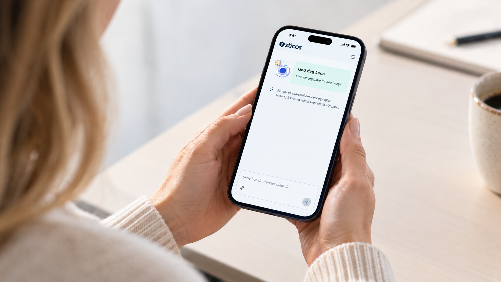 Kvinne bruker norsk assistentapp ved skrivebordet