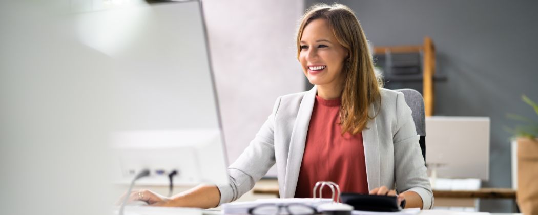 smilende dame som jobber med viderefakturering